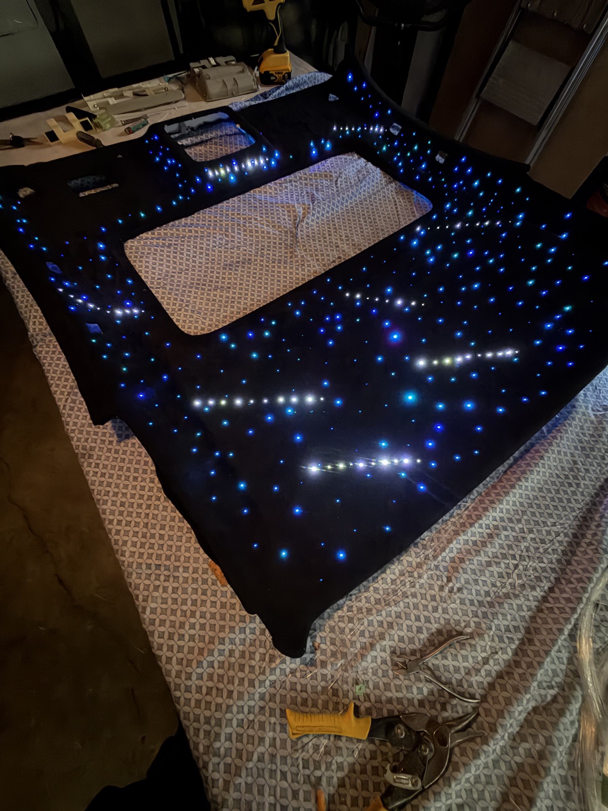 Luces de fibra óptica azules y blancas sobre un headliner negro.