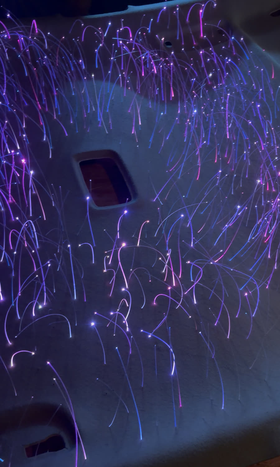 Fibras ópticas iluminadas durante una instalación de starlight.