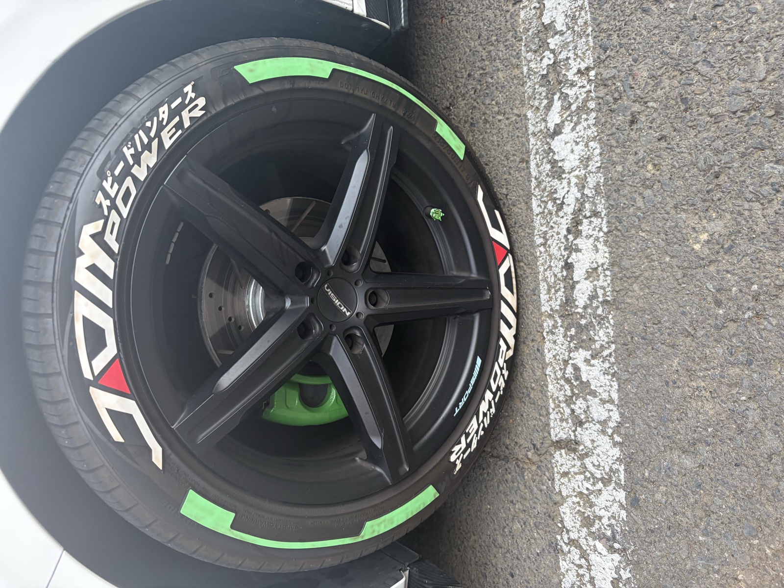 Rueda con decales verdes, letras blancas y caliper verde.